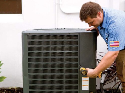 HVAC technician from Omni Home Comfort servicing a condensing unit for a Comfort Club member